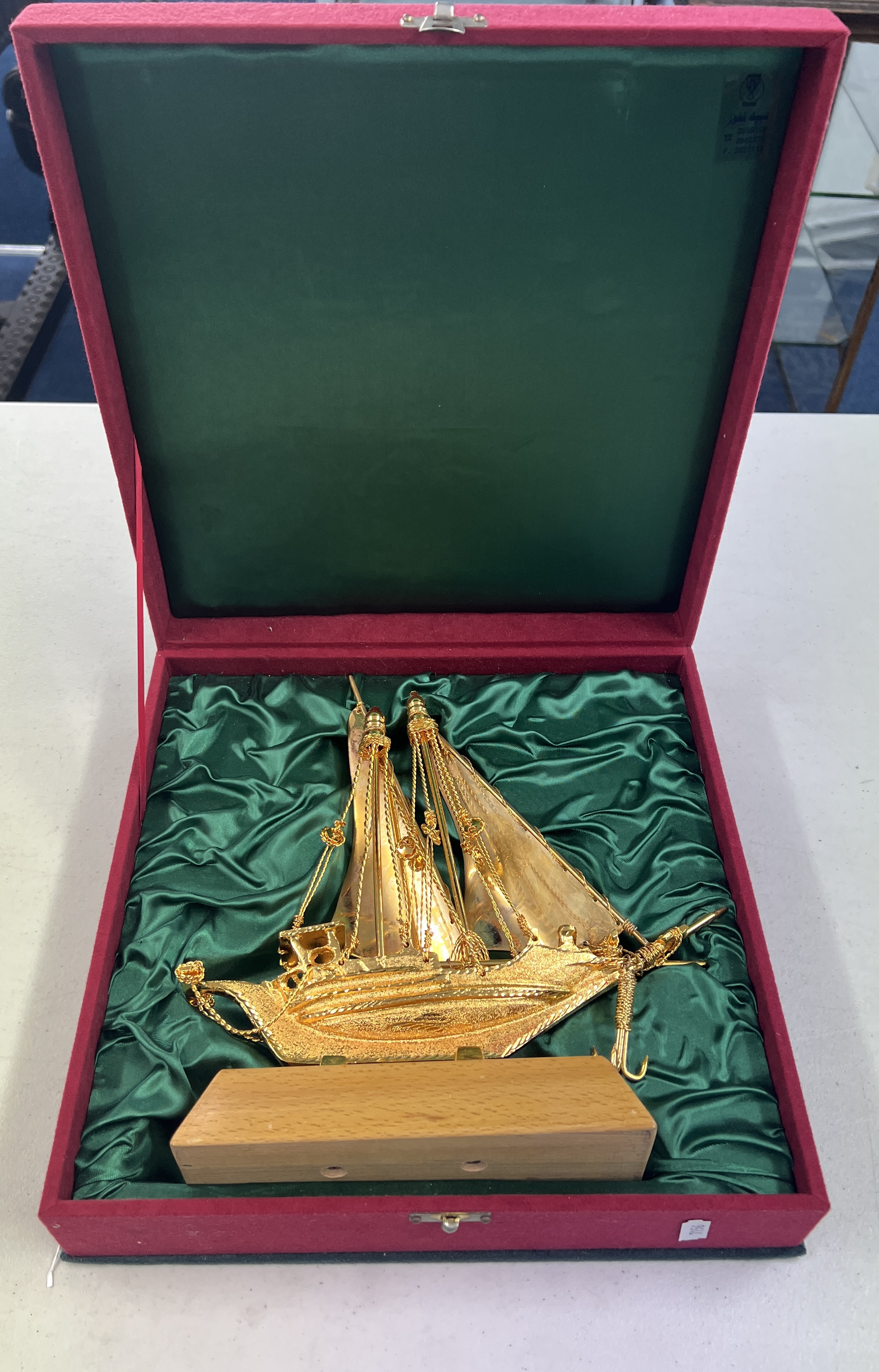 A gilt metal model of a twin masted ship on plinth. Height 28cm in fitted presentation case