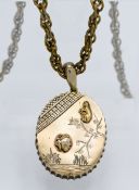 A silver gilt pendant lined with a mirror, on guilt rope twist chain with landscape and inset
