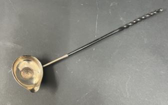 A silver punch ladle, with Queen Anne silver coin 1711 set in base with a whale bone handle.