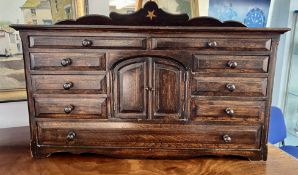 A miniature model of a sideboard with chequered inlay. With an arrangement of drawers and