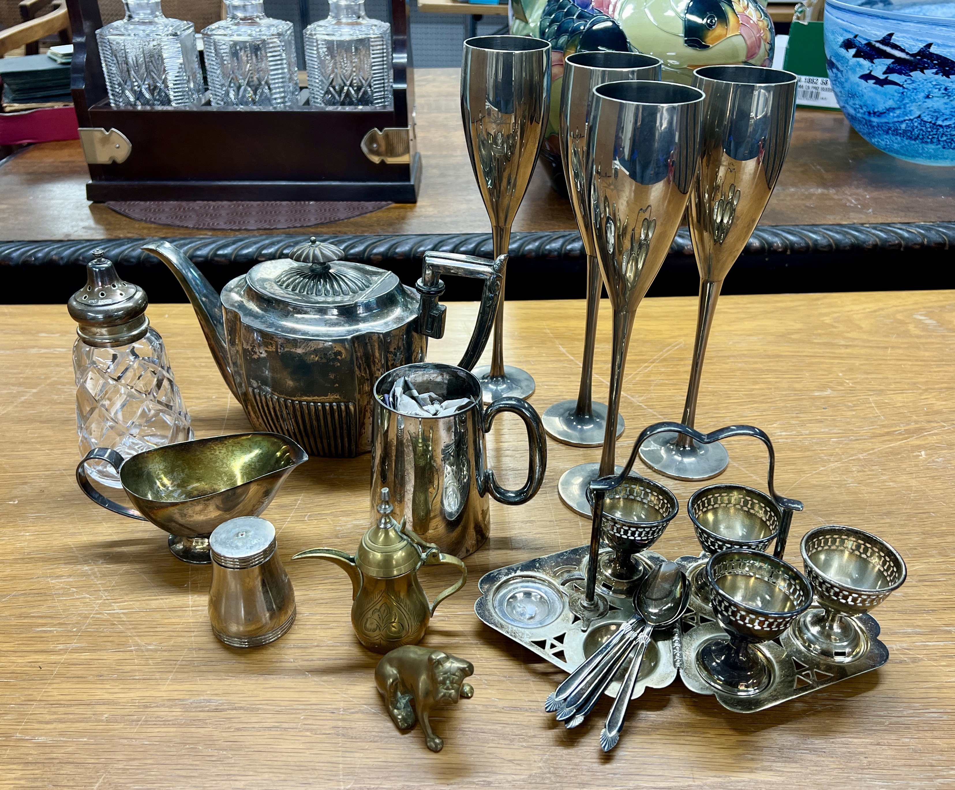 A collection of silver plated wares including a silver and glass sugar caster.