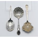 Two silver caddy spoons and a silver castor spoon. Comprising the castor spoon 'Sheffield 1934 TC &