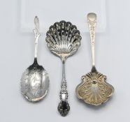 Two silver caddy spoons and a silver castor spoon. Comprising the castor spoon 'Sheffield 1934 TC &