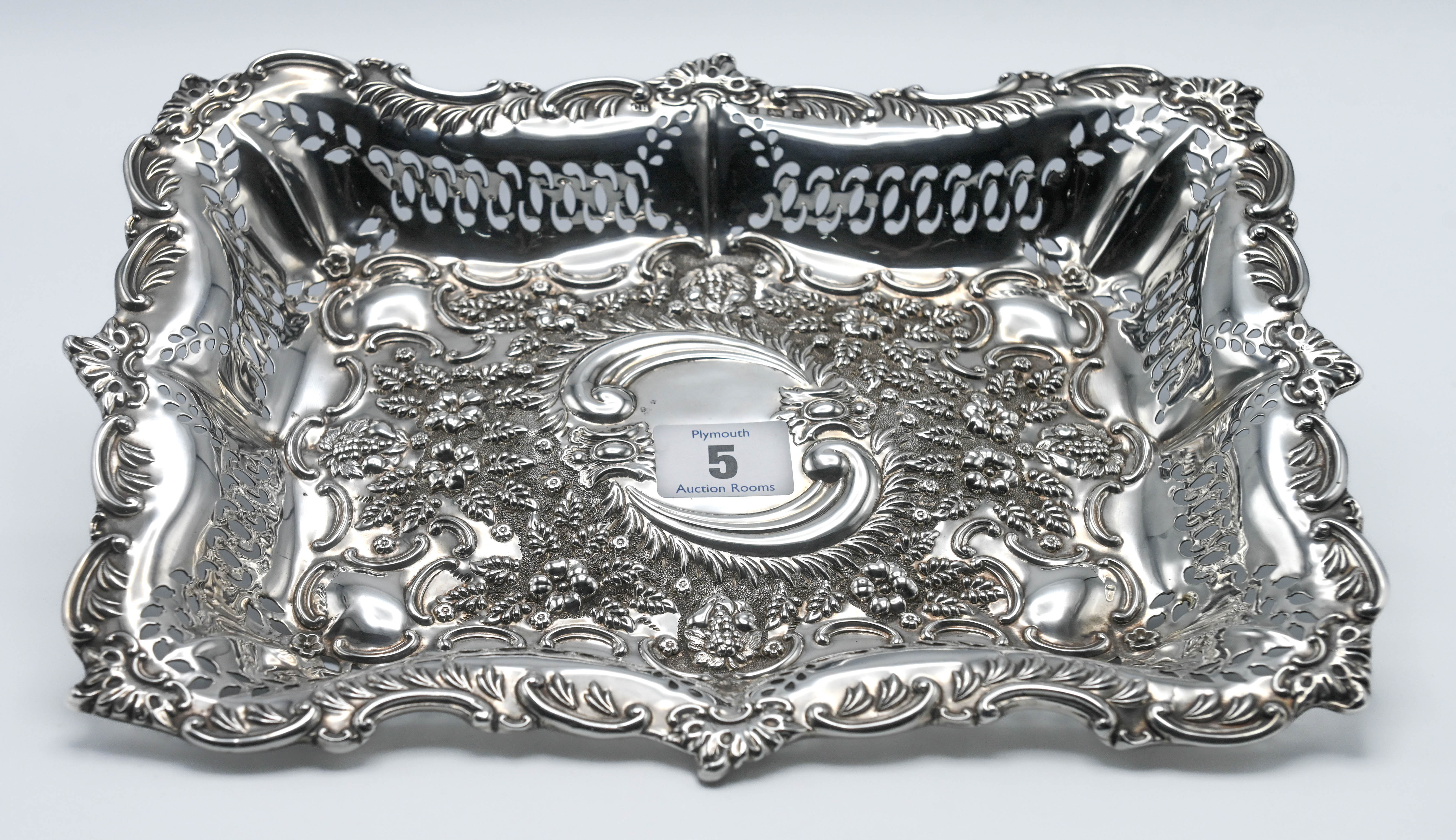 An Edwardian rectangular silver and pierced shallow dish, decorated with embossed flowers and