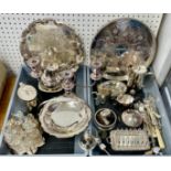 A quantity of silver plated wares including serving trays, candelabra, cake stands, seven bottle