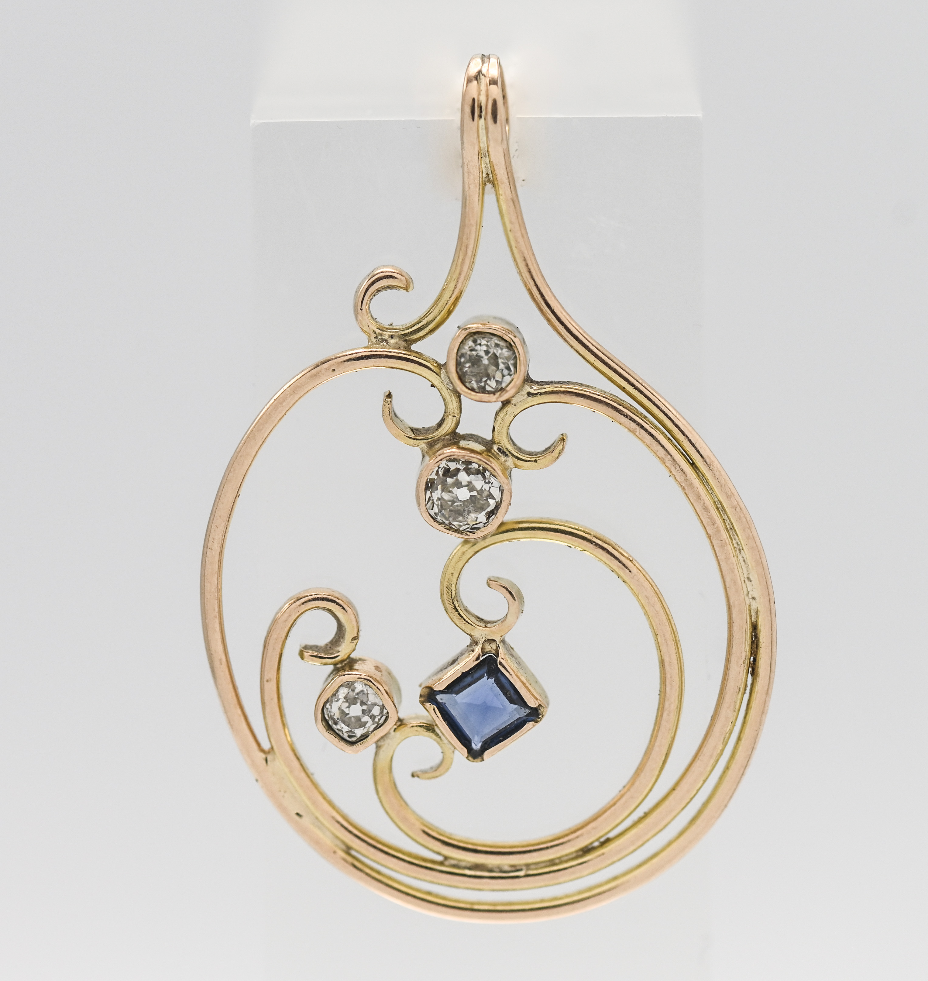 A gold diamond and sapphire pendant of contemporary design.