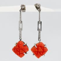 A pair of white gold and coral earrings.