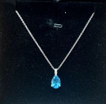 An 18ct white gold diamond and topaz pendant on chain.