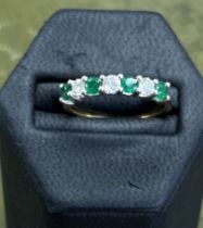 An emerald and diamond seven stone ring set in yellow gold, size R.