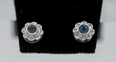 A pair of 9ct white gold diamond an topaz 'Flower' style studs.