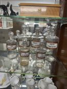 A group of six antique glass chemist bottles, each with original labels including 'Aqua