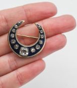 An antique enamelled and diamond crescent shaped brooch (not hallmarked).