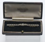 A diamond set bar brooch, cased, length 70mm.