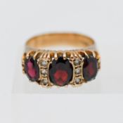 A 9ct gold three stone garnet ring set with diamonds, size O.