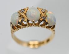 An 18ct gold three stone opal and diamond ring, size K/L.