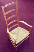 A beech ladder back nursing elbow chair, with rush seat height 32cm, overall height 102cm.