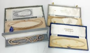 Four faux pearl necklaces in boxes.