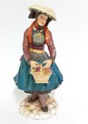 A German Meissen figurine depicting a flower girl in traditional dress, marked.