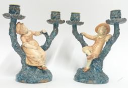 A pair of late 19th century Royal Worcester candlesticks, marked 1125, of tree form with boy and