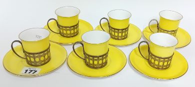 A set of six Shelley coffee cups and saucers, gold rimmed, held in silver carriers hallmarked