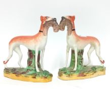 A pair of Staffordshire hunting dogs on a green base, height 20cm. (2)
