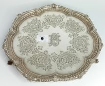 A Victorian Silver waiter, with engraved foliate decoration and embossed borders, on claw and ball