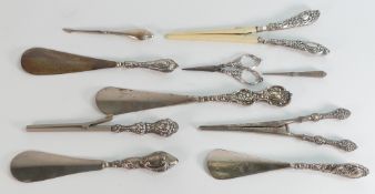 10 silver handled implements including 4 x shoe horns, 3 x tongs / stretchers, nail implement,
