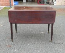 19th Century Drop Leaf Table with one locking and one false drawer on Brass Castors. Height: 72cm