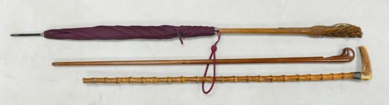 Two Walking Sticks together with a carved duck umbrella. Length at most: 100cm
