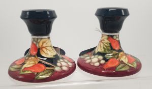A pair of Moorcroft squat candlestick holders in the winter harvest pattern 8.5cm height