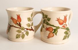 A pair of Moorcroft Rosehip patterned mugs,