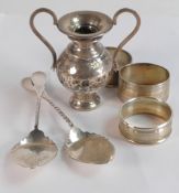 A collection of hallmarked silver items including serviette rings, spoons, miniature trophy, 172.9g.