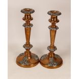 A pair of early 20thC copper and pewter candlesticks, each copper candlestick decorated with