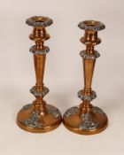 A pair of early 20thC copper and pewter candlesticks, each copper candlestick decorated with