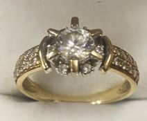 9ct yellow gold ring set with large cubic zikonia central stone surrounded by 6 smaller stones set