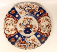 A Japanese Imari Plate depicting Flowers in Vase with outer reserves showing exterior fenced