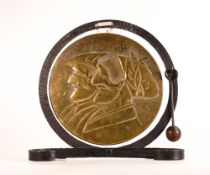 Rustic wrought Iron and Brass dinner gong. Embossed with faces of French peasants. Striker