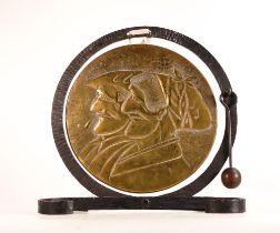 Rustic wrought Iron and Brass dinner gong. Embossed with faces of French peasants. Striker