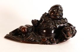 Chinese carved hardwood figure of reclining Buddha with mythical horned beast under his left arm.