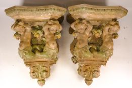 Pair of moulded ceramic wall brackets with painted decoration, measuring 36cm high x 23.5cm x 22.5cm