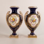 A pair of Coalbrookdale urns with hand painted trophy reserves to front and floral spray reserves