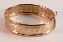 9ct gold two colour decorated bangle, 20g.