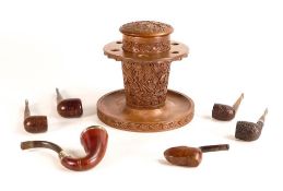 A carved smokers stand together with five pipes, Dunhill Estate pipe noted. Height of stand: 19cm (