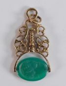 9ct gold ornate fob with carved Jade swivel, gross weight 9.2g.