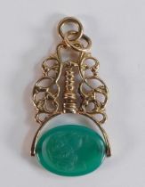9ct gold ornate fob with carved Jade swivel, gross weight 9.2g.