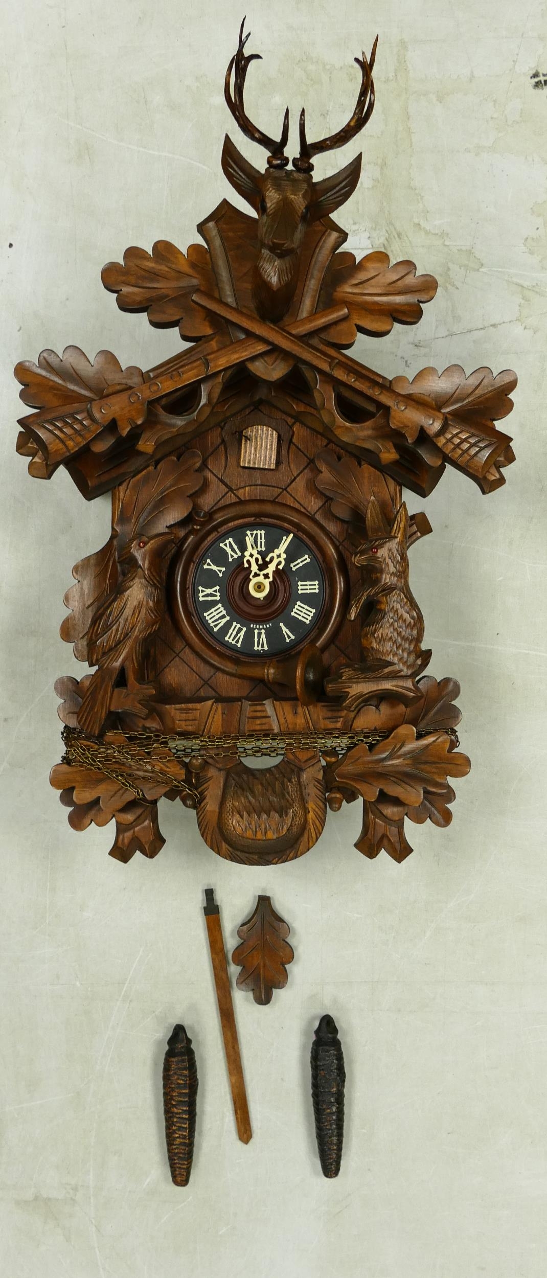 A 20th Century Chip Carved German Cuckoo Clock. Height of Clock, excl. chains and pendulum: