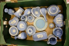 A collection of Blue Wedgwood Jasperware including bud vases, pin dishes, lidded boxes, candle