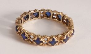 Yellow metal ladies eternity ring set with blue stones, size Q/R, 2.6g.