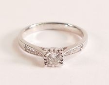 . 9ct white gold illusion set diamond ring with diamond shoulders The 9ct white gold band is stamped
