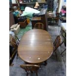 Oval Oak extending dining table together with 4 matching spindle back Windsor dining chairs (4